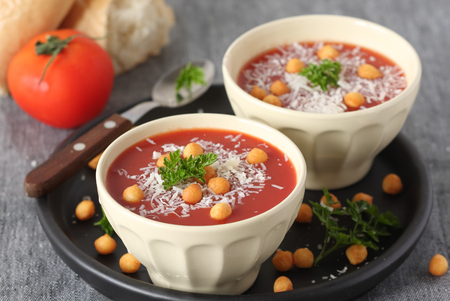 Fresh tomato soup with parmesan and croutons in a white bowlの写真素材