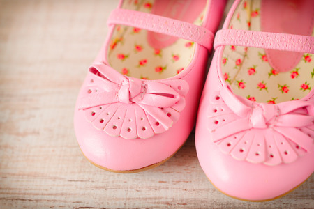Detail of a pink girl shoes over wooden deck floor. Filtered image.の写真素材