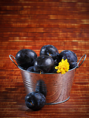 Fresh ripe plums in a tin bowl.の写真素材