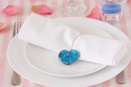 Valentines day table setting with plate, knife, fork, and blue heartの写真素材