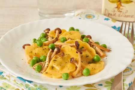 Tortellini with mushrooms and peas on a tableの写真素材