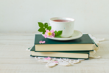 Cup of tea with rose hips on booksの写真素材