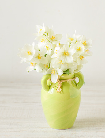 Jasmine flowers in a green small vase, selective focusの写真素材