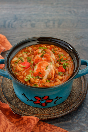 Italian lentil stew with bolognese sauce and sausage in a bowl with parsley on rustic wooden tableの写真素材