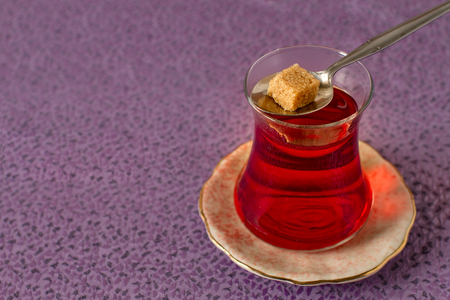 Oriental tea in traditional glass with one sugar cubeの写真素材