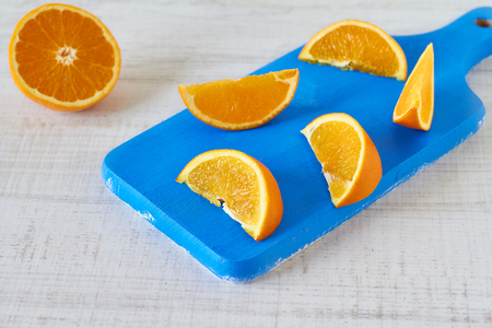 Orange slices on vintage blue wooden kitchen boardの写真素材