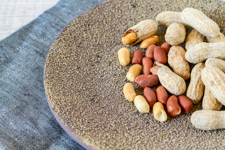 Raw peanuts or groundnuts on a plate, close upの写真素材