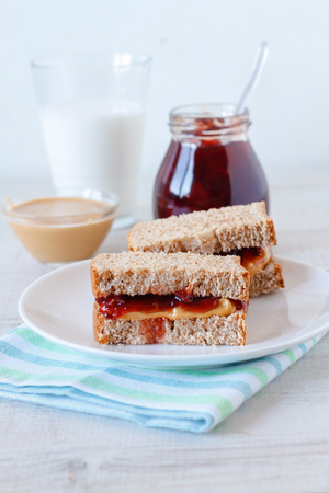 Peanut butter and jam sandwich with a glass of milkの写真素材