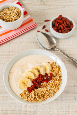 Superfoods smoothies bowl with banana, oats and goji berry . Overhead, top view, flat lay.の写真素材