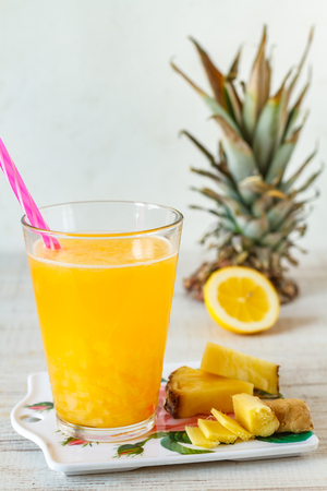 Pineapple,lemon and ginger juice in glassware on wooden table.の写真素材