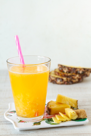 Pineapple,lemon and ginger juice in glassware on wooden table.の写真素材