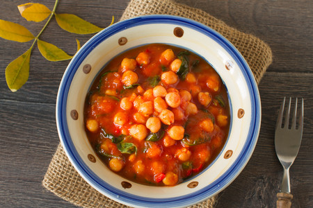 Homemade rustic chickpea and spinach curry on a tableの写真素材