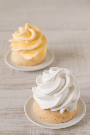 Still life in vintage style with meringue mini cake and on rustic wooden tableの写真素材