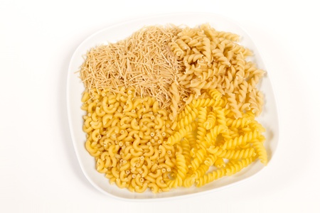 An assortment of four kinds of italian pasta on a white plate and white backgroundの写真素材