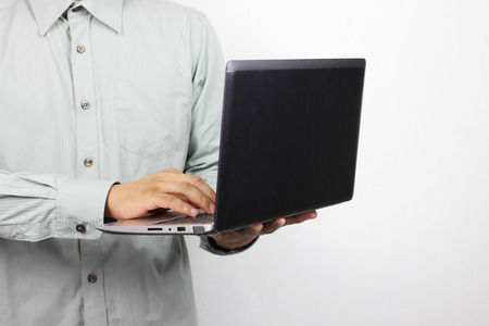 business man is holding a computer laptop for his work.の写真素材