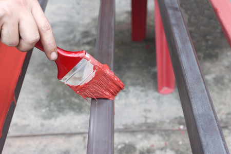 Hand of a man worker holding a paintbrush painted steel for industrial work and ideas in your work.の写真素材