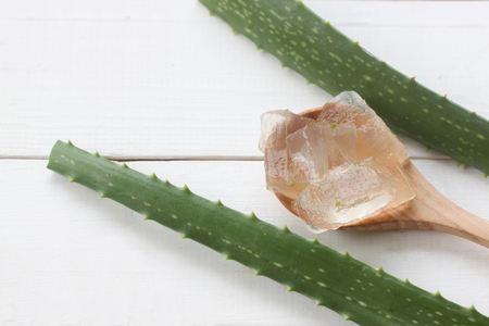 Aloe vera gel in a wooden spoon placed on a white wooden floor for design in herb concept of your work.の写真素材