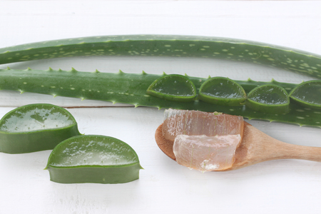 Aloe vera gel in a wooden spoon placed on a white wooden floor for design in herb concept of your work.の写真素材