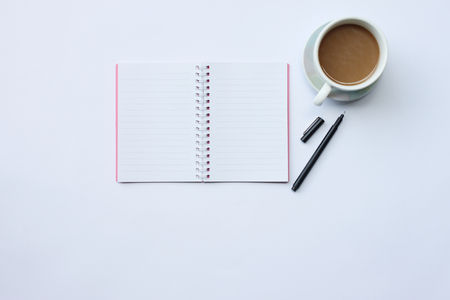 Notebook,pen,and coffee mug placed on a white desk In the office and have copy space the concept in your work.の写真素材