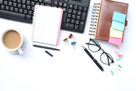 Notebook,pen,keyboard and coffee mug placed on a white desk In the office and have copy space the concept in your work.の写真素材