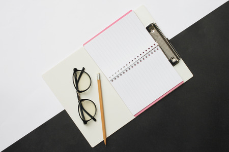 Top view notebooks pencils and glasses placed on a black and white desk In the office and have copy space Ideas in your work.の写真素材