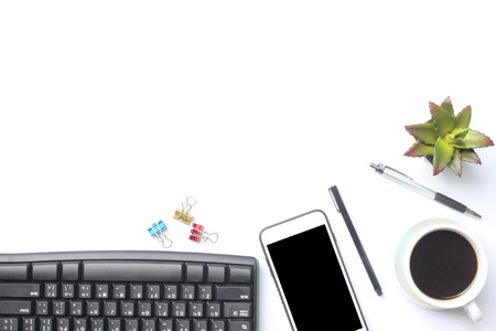 Keyboard, smartphone, notebook, cup coffee, pen and supplies place on a white desk in the office and...