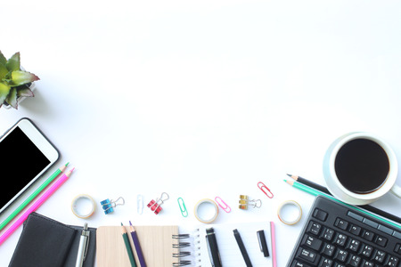 Keyboard, smartphone, notebook, cup coffee, pen and supplies place on a white desk in the office and have copy space for your design.の写真素材
