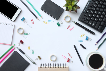 Keyboard, smartphone, notebook, cup coffee, pen and supplies place on a white desk in the office and have copy space for your design.の写真素材