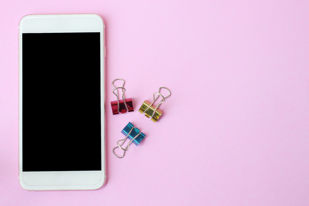 Top view smartphone and clips on pink floor and have copy space to design for you.の写真素材