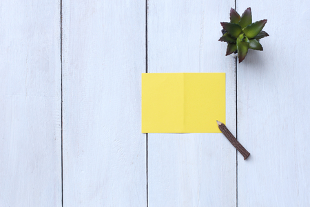 Top view yellow paper, pencil and flower pot on white wood floor and have copy space to for your design.の写真素材