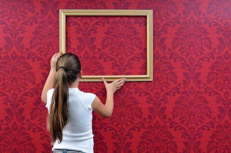 girl hangs up a picture frameの写真素材