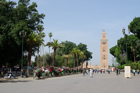 MARRAKESH, MOROCCO - MAY 9, 2014  Horse and carriages waiting for customers and tourists close to landmark of mosque and near to market square  Marrakesh, Morocco May 9, 2014のeditorial素材