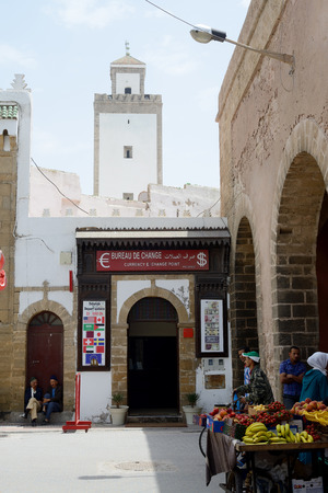 ESSAOUIRA, MOROCCO - MAY 12, 2014  Street scene showing bureau de change, fruit seller and mosque  Essaouira, Morocco  May 12, 2014 のeditorial素材