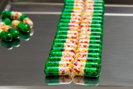 Medicinal capsules in row on drug count trayの写真素材