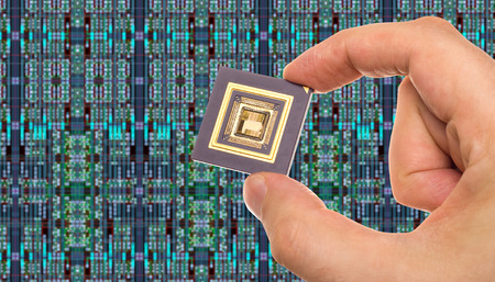 Microprocessor in hand in front of chip layout