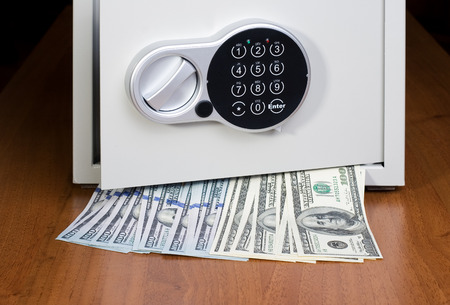 Safe with dollars on wooden shelfの写真素材
