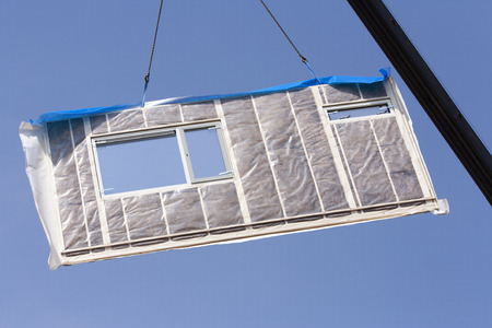Wall lifted by a crane on a construction siteの写真素材