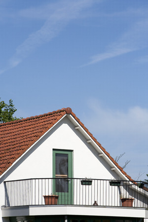 Red roof tiles on a loft with balconyの写真素材