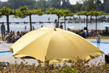 Gold colored parasol near swimming pool at the lake Kralingen in Rotterdam, the Netherlandsの写真素材