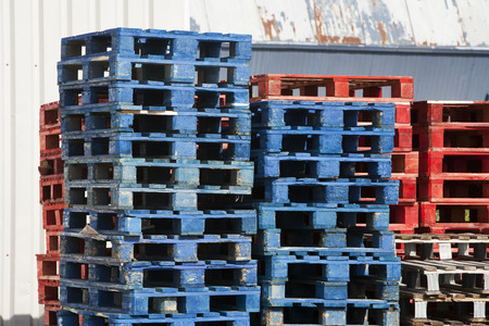 A stack of blue and red wooden pallets