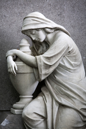 Sculpture of a religious woman on a grave in Rotterdam, watching over and protecting the lost oneの写真素材
