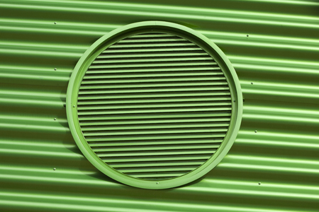 Green metal air grate in a green metal buildingの写真素材