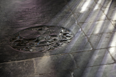 Black worn ancient tombstone on the floor of a church in Dordrecht in the Netherlandsの写真素材