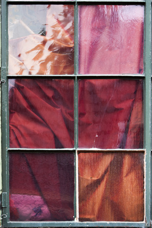 Curtain behind window with glass in different colors and textureの写真素材