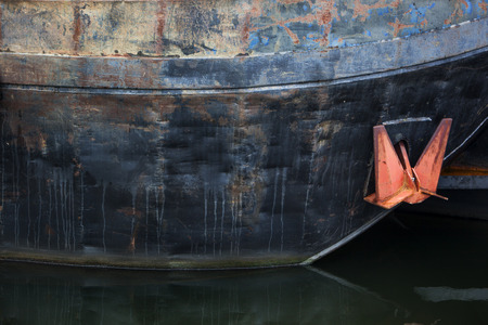 Rusty vintage barge with red anchor in the Netherlandsの写真素材