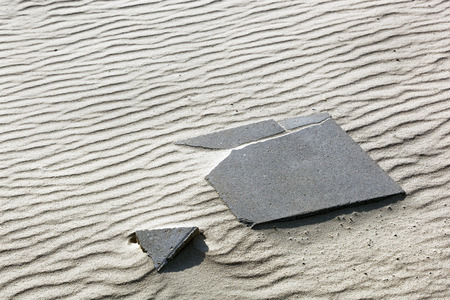 Missing piece of a broken paving stone puzzle in the sandの写真素材