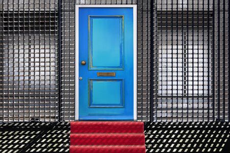 Manipulated photo of a red carpet leading to a building with a blue door and bricked-up windows behind a security fence. Usable for security, protection or insurance conceptsの写真素材