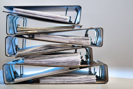 Stack of office folders with archived paperwork in red lightの写真素材