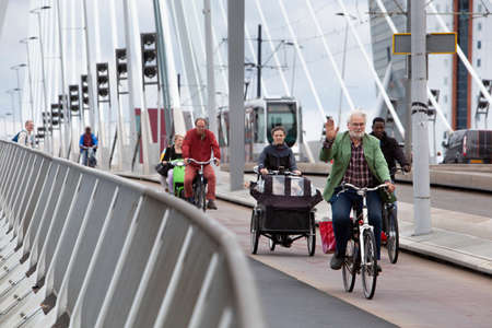 Rotterdam, Netherlands â€“ September 13, 2021: : Cyclists and a tram on the Erasmus bridge in...