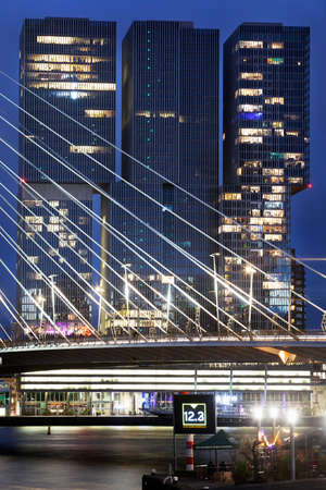 Rotterdam, Netherlands â September 15, 2021: Urban twilight view of the Erasmus bridge in Rotterdam and the building De Rotterdam by architect Rem Koolhaas.のeditorial素材